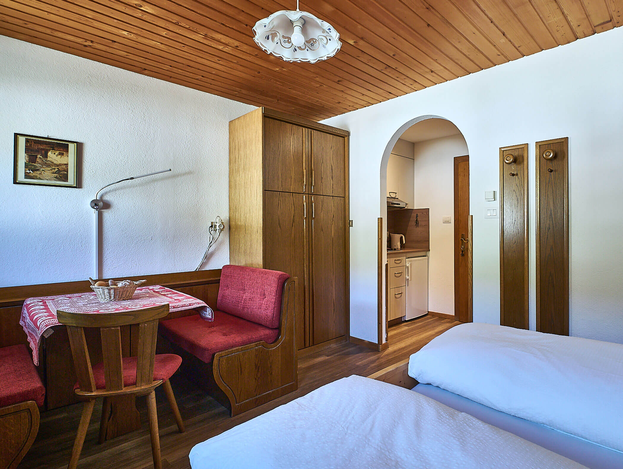 Eckbank und Doppelbett im Apartment Sarl