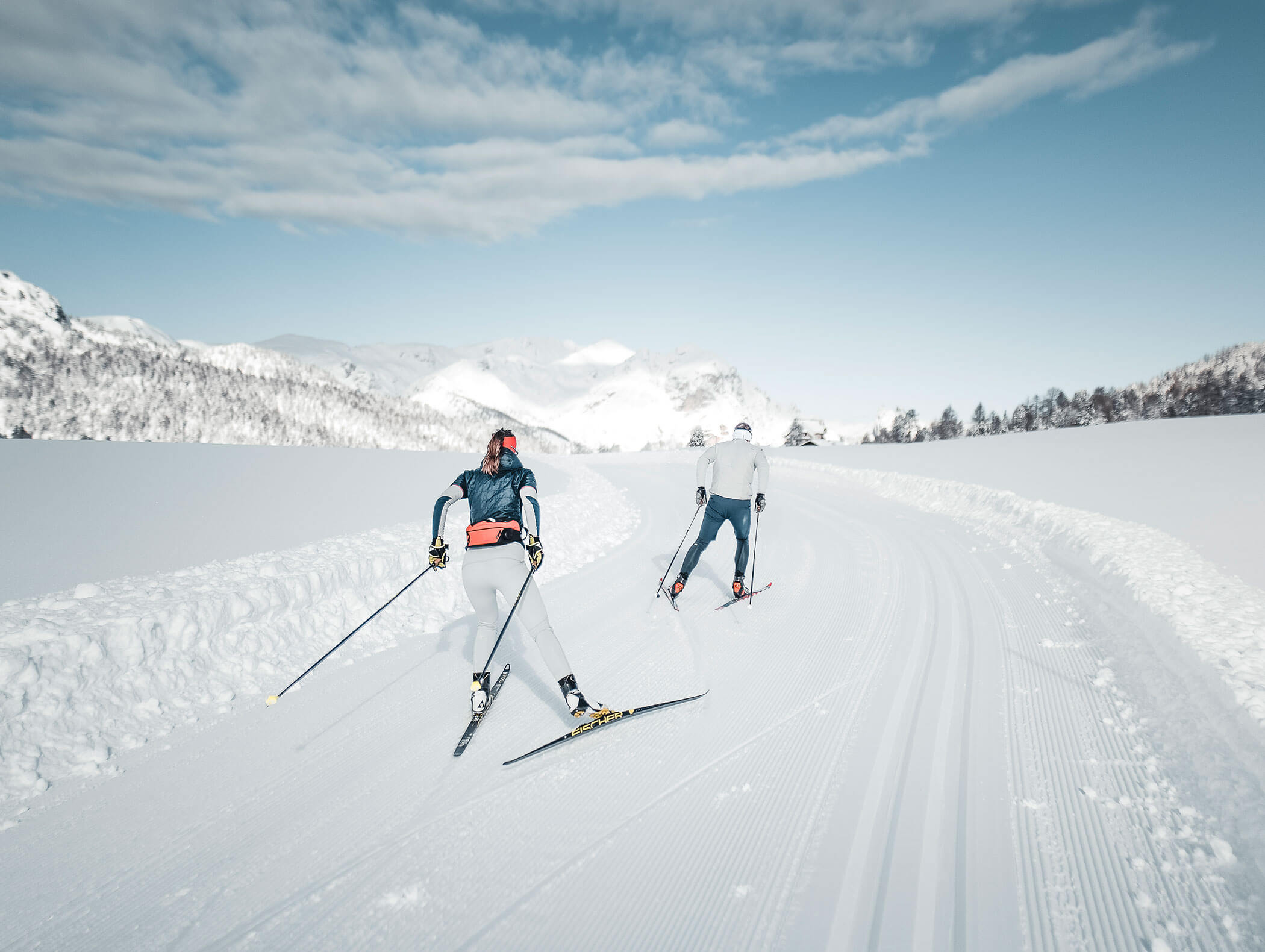 Two cross-country skiers skating on the trail