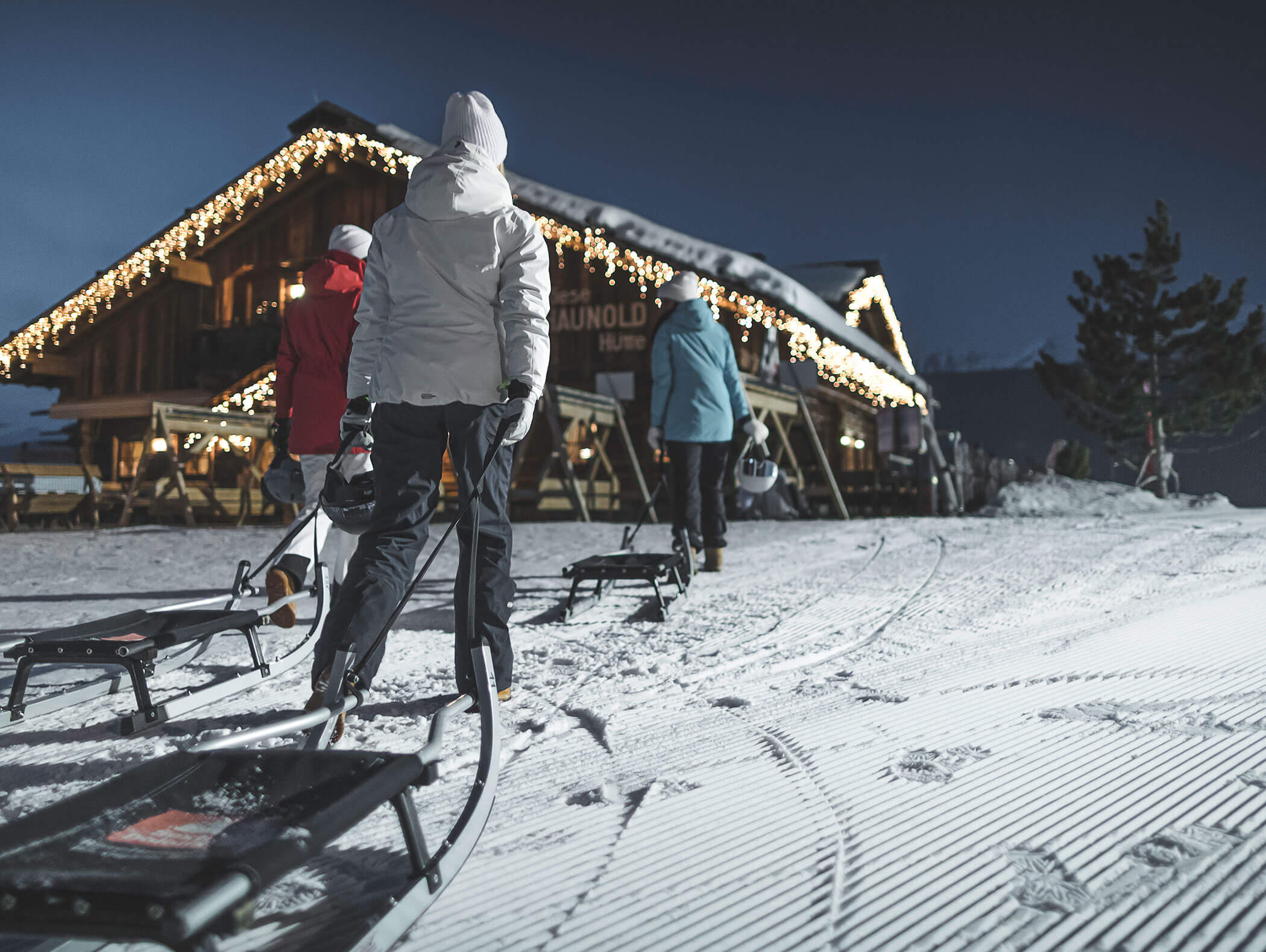 Three people night sledding